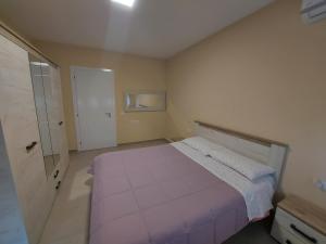 a bedroom with a large bed and a door at K2 HOME - 6th floor in Tirana