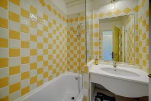 een badkamer met een bad, een wastafel en een spiegel bij IMMOGROOM - 2 Rooms - Renovated - Pool - Air conditioning - Parking - in Cannes