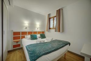 een slaapkamer met een bed met een groene deken erop bij IMMOGROOM - 2 Rooms - Renovated - Pool - Air conditioning - Parking - in Cannes