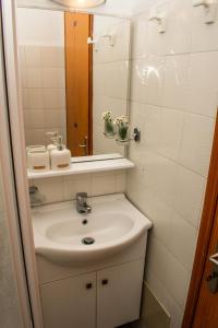 a bathroom with a sink and a mirror at Kiki's Apartments in Néos Pírgos