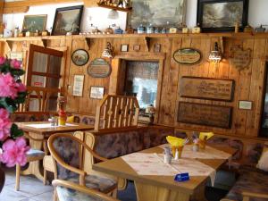 ein Restaurant mit Holzwänden, Tischen und Stühlen in der Unterkunft Landhotel Goldener Becher in Limbach - Oberfrohna