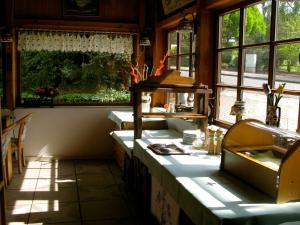 eine Küche mit einer Theke, einem Waschbecken und Fenstern in der Unterkunft Landhotel Goldener Becher in Limbach - Oberfrohna