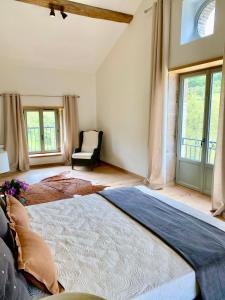 - une chambre avec un grand lit et une chaise dans l'établissement Maison du Cocher, à Cluny