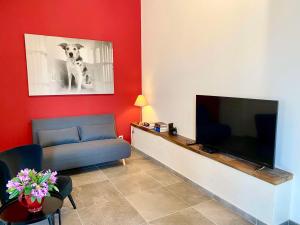 a living room with a flat screen tv and a couch at Maison du Cocher in Cluny
