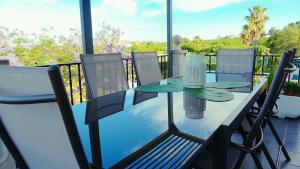 y balcón con mesa de cristal y sillas. en Los Olivos en Chiva
