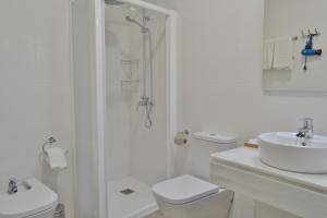 y baño blanco con ducha, aseo y lavamanos. en SunShine Cruz Conde en Córdoba