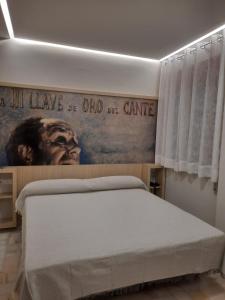 a bed in a room with a poster on the wall at Hotel Mairena in Mairena del Alcor