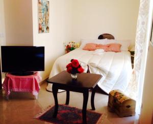 a bedroom with a bed and a table with a tv at Magnolia House in Taurianova