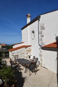 a patio with a table and chairs in front of a building at Holiday home Ana in Cres