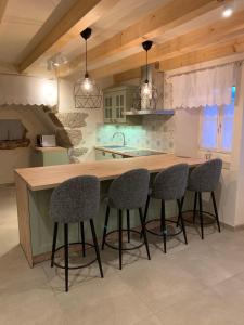 a kitchen with a wooden counter with four bar stools at Holiday home Ana in Cres