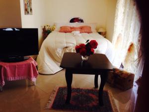 una camera da letto con un letto e un tavolo con fiori di Magnolia House a Taurianova