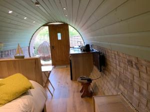 a room with a bed and a kitchen in a room at Romantic escape luxury Hobbit house with Hot tub! in Sheerness