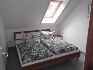 Bett in einem Zimmer mit Fenster in der Unterkunft Appartementhaus Zur Schaabe in Glowe