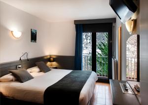 - une chambre avec un grand lit et une grande fenêtre dans l'établissement Hotel Mila, à Encamp