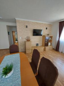 a living room with a table and chairs and a television at Apartmani Delač in Vodice