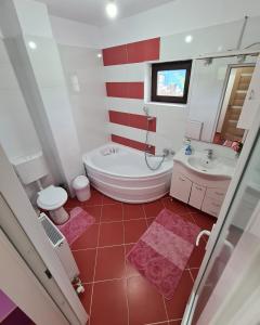 a red and white bathroom with a tub and a sink at Camera la vila in Constanţa