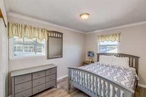 a bedroom with a bed and two windows at Colonial Shores Resort in Hampton Bays