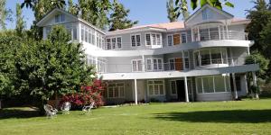 a large white house with a large yard at Hotel Reego in Skardu