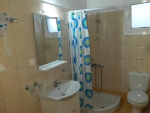 a bathroom with a sink and a toilet and a shower at Olive Tree Apartments in Parga