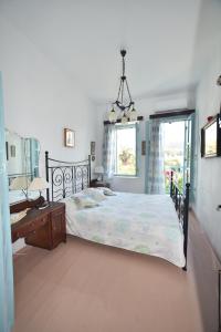 um quarto com uma cama, uma secretária e uma janela em Traditional house by the sea em Mandrákion