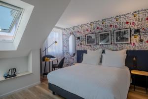 a bedroom with a white bed and a wall with flowers at Ferdinand Hotel Tours in Tours
