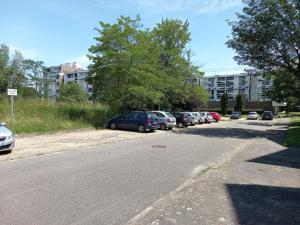 Une rangée de voitures garées sur le côté d'une rue dans l'établissement Aux portes de Bordeaux Le Compostelle MindUrGuest, à Pessac