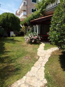 a garden with a stone walkway next to a building at Villa Verde Apartments and Rooms in Premantura