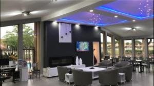 une salle à manger avec des tables, des chaises et des lumières bleues dans l'établissement Americas Best Value Inn Angleton, à Angleton