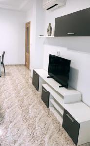 Televízia a/alebo spoločenská miestnosť v ubytovaní Apartamento Lola