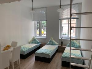 pokój z dwoma łóżkami, stołem i dwoma oknami w obiekcie Raisa Apartments Lerchenfelder Gürtel 30 w Wiedniu