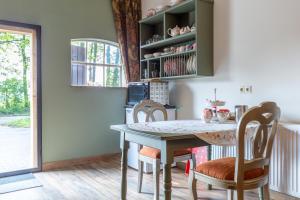 een keuken met een tafel en stoelen in een kamer bij Bed and Breakfast De Boerderij Kamer in Nutter