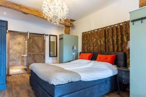 NutterにあるBed and Breakfast De Boerderij Kamerのベッドルーム1室(大型ベッド1台、シャンデリア付)