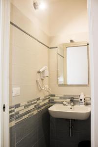 bagno con lavandino e specchio di Hotel Sant'Orsola City House a Bologna