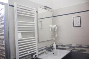 bagno con lavandino e specchio di Hotel Sant'Orsola City House a Bologna