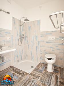 a bathroom with a tub and a toilet and a sink at Hotel Muita di Mari in Santa Teresa Gallura