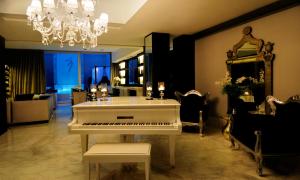 a white piano in a living room with a chandelier at 1828 Smart Hotel Boutique in Buenos Aires