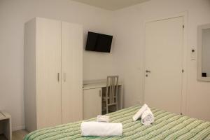 a bedroom with a bed with towels on it at Hotel Sant'Orsola City House in Bologna