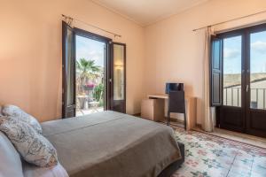 a bedroom with a bed and a sliding glass door at Hotel Vittorio Veneto in Ragusa