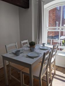 a dining room table with chairs and a large window at Riverside Apartment York in York