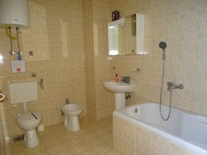 a bathroom with a sink and a toilet and a bath tub at Zana Apartments in Stan Trigraci