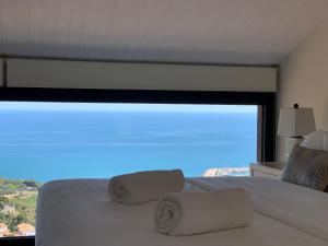 a bedroom with a white bed with a large window at Sitges Spaces Sea View Villa- 6 Bedrooms, 5 bathrooms, 2 private pools, Near center in Sitges