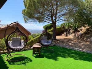 two chairs and a table on a green lawn at Sitges Spaces Sea View Villa- 6 Bedrooms, 5 bathrooms, 2 private pools, Near center in Sitges