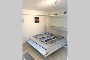 a bedroom with a white bed with blue pillows at Apartment in grüner Umgebung-EG in Allensbach