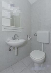 een witte badkamer met een toilet en een wastafel bij Apartment in Biograd na Moru with Terrace, Air conditioning, Wi-Fi (4801-2) in Biograd na Moru