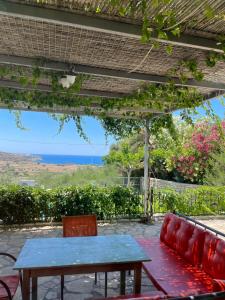 a patio with a table and a couch and the ocean at Villa Diana in Pitsidia