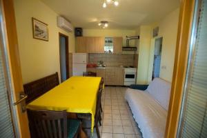 een keuken met een gele tafel en een bed bij 2-bedroom Apartment with terrace in Povile 3542-1 in Povile