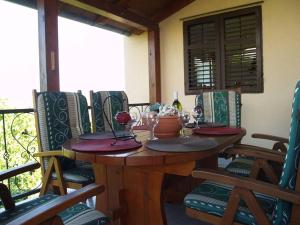 drewniany stół z krzesłami i kieliszkami do wina na ganku w obiekcie Holiday house in Kukljica with sea view, terrace, air conditioning, Wi-Fi (4572-1) w mieście Kukljica +21 zdjęć