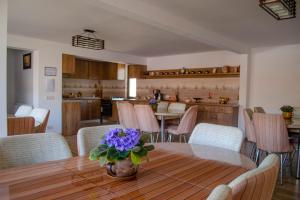 a kitchen and dining room with a table with purple flowers at Residence Ghinita Bucovina in Gura Humorului