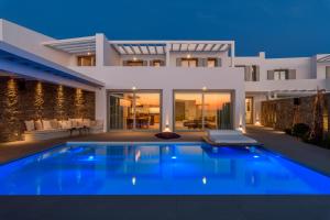 a villa with a swimming pool in front of a house at Splendid Mykonos Luxury Villas & Suites in Mikonos