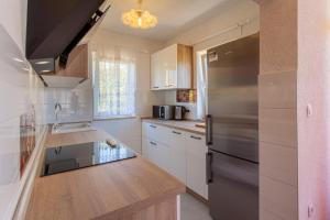 a kitchen with white cabinets and a stainless steel refrigerator at Apartment in Cres with sea view, balcony, air conditioning, Wi-Fi (4249-1) in Cres